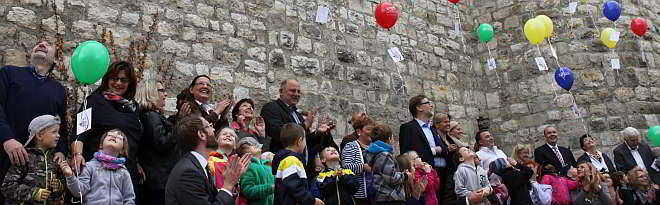 Kinder der Kindertagesstätte Spatzennest lassen zusammen mit den Teilnehmern der Vollversammlung Bündnis für Familie ihre Luftballons fliegen.